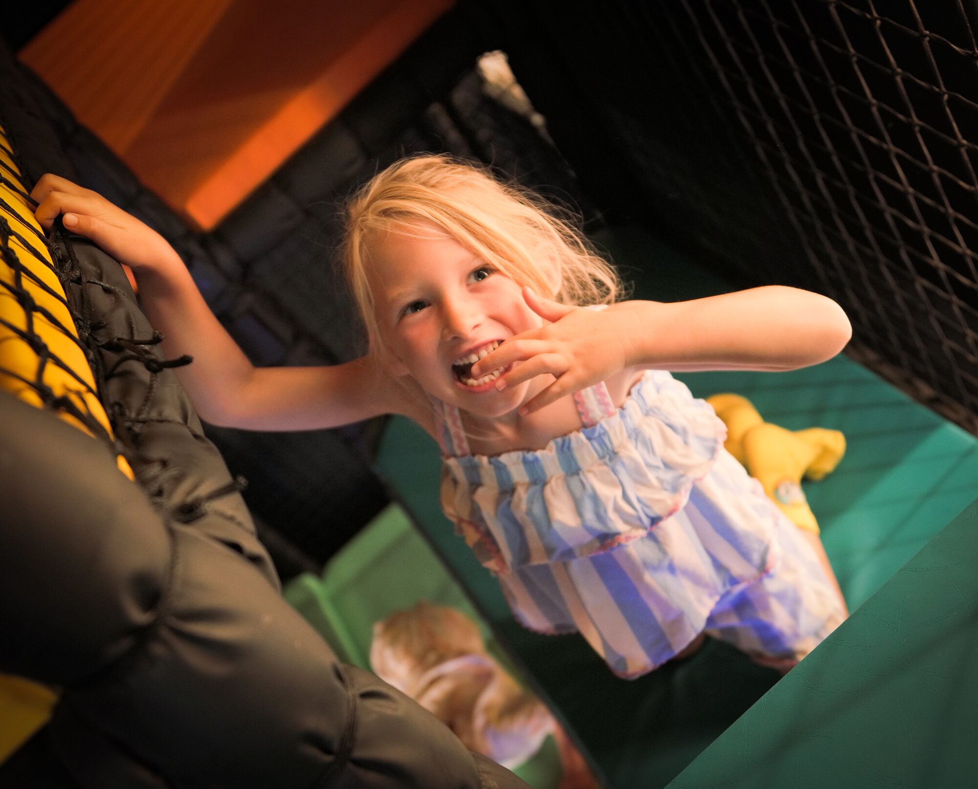 A child laughing in the soft play area