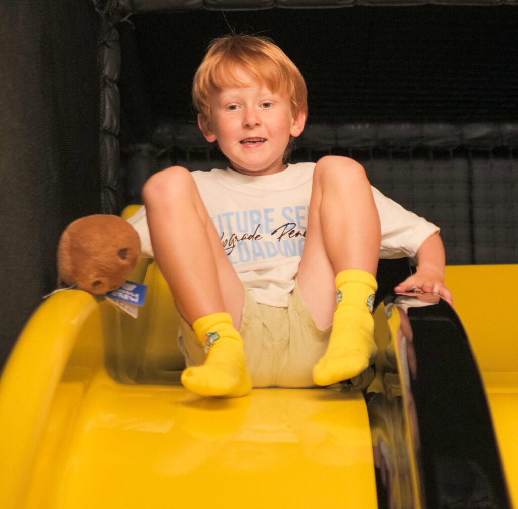 A child on the yellow slide in the Yo Coast soft play