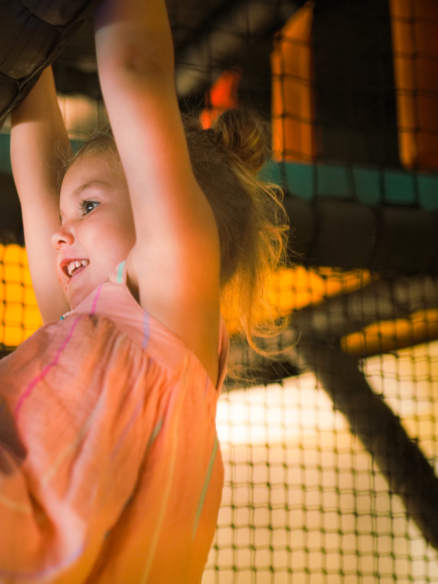 A child climbing the soft play netting