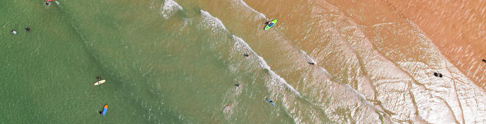 Aerial view of surfers on Polzeath beach